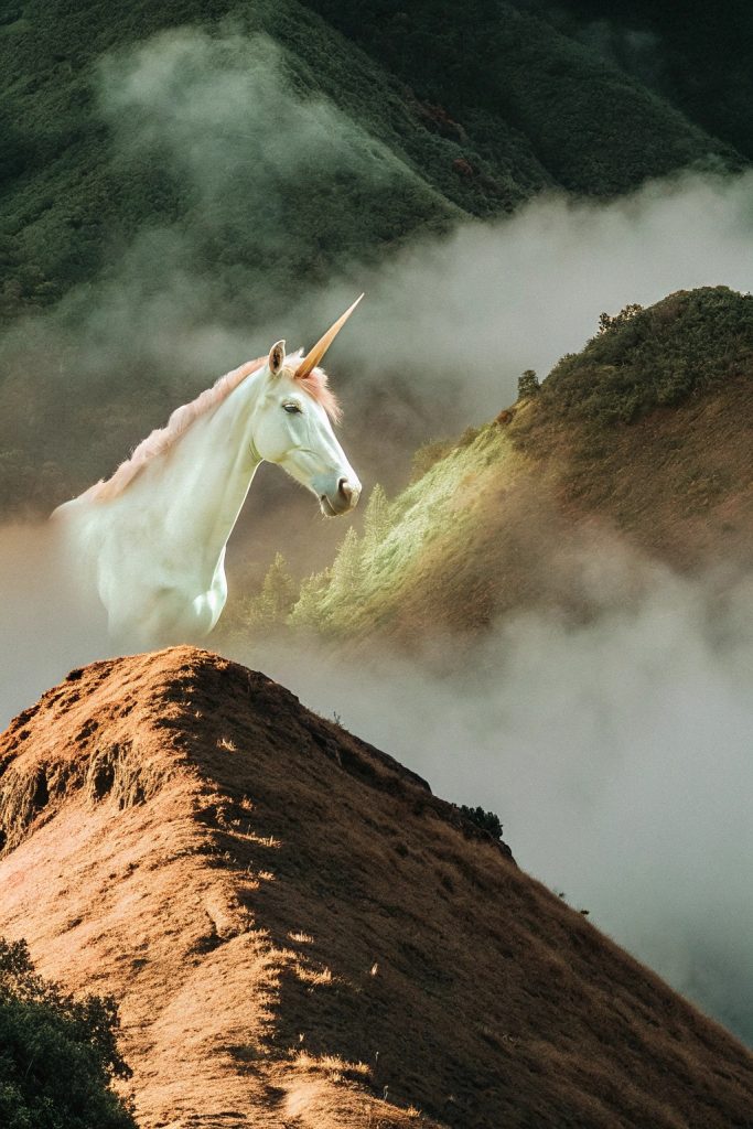 Unicorn made of swirling mist and fog, pearlescent glowing horn partially visible, misty mountain top, ethereal creature.